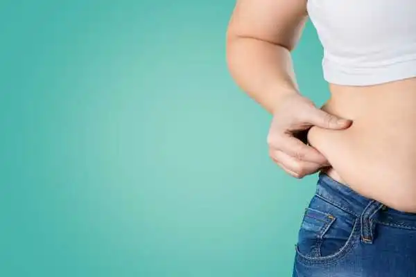 Image of woman pinching her love handles to show weight gain Herne